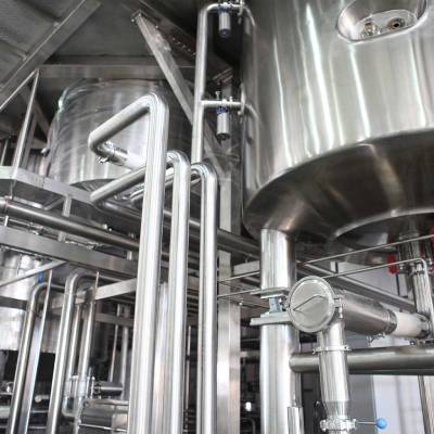 Halle mit Rohren und Behältern in einer Industrieanlage.