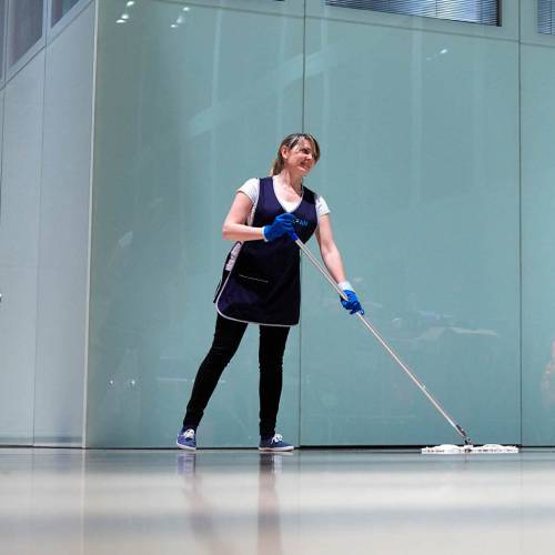 Mitarbeiterin von Clean Excellence GmbH Gebäudereinigung reinigt im Eingangsbereich